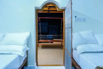 a mirror in a room with two beds and a doorway at Belljem Homes -your own private resort -4 BHK FF in Trichūr