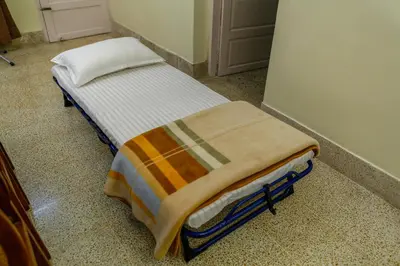 a small bed with a blanket on it in a room at Belljem Homes -your own private resort -4 BHK FF in Trichūr