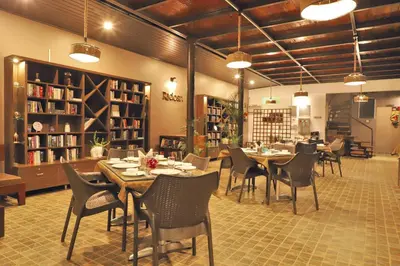 a dining room with tables and chairs in a library at Radosri in Coonoor