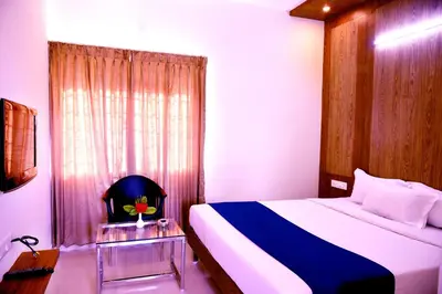 a bedroom with a large bed and a window at Vismaya Comforts in Mysore