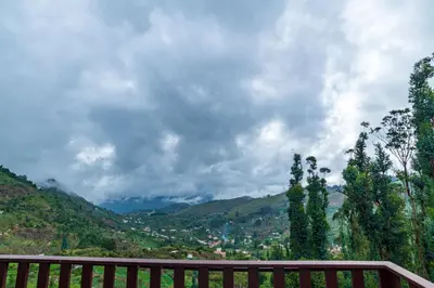 a wooden bench with a view of a valley at Warmth Hill Crest in Kodaikānāl