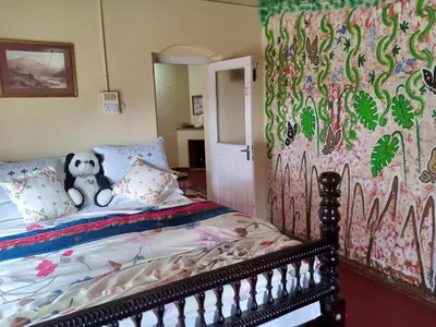 a bedroom with a bed with a teddy bear on it at Zeus Bungalow in Kotagiri