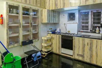 a kitchen with wooden cabinets and a stove at Belljem Homes -your own private resort -6 BHK S in Trichūr