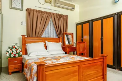 a bedroom with a wooden bed and a window at Belljem Homes -your own private resort -7 BHK in Trichūr