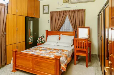 a bedroom with a wooden bed with a dresser and a mirror at Belljem Homes -your own private resort -7 BHK in Trichūr
