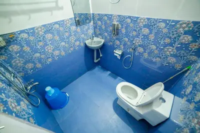 a blue bathroom with a toilet and a sink at Belljem Homes -your own private resort -7 BHK in Trichūr