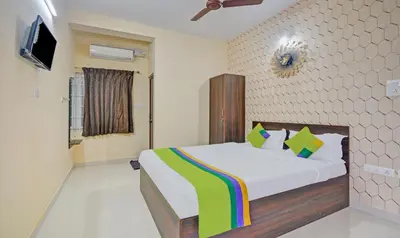 a bedroom with a bed and a tv on a wall at Treebo Everest Residency Tidel Park, 15 Mins From Coimbatore International Airport in Coimbatore