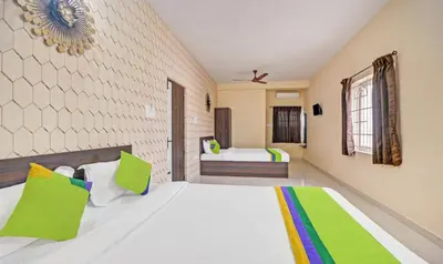 a bedroom with a large white bed with green pillows at Treebo Everest Residency Tidel Park, 15 Mins From Coimbatore International Airport in Coimbatore