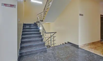 a staircase in a building with metal railing at Treebo Everest Residency Tidel Park, 15 Mins From Coimbatore International Airport in Coimbatore