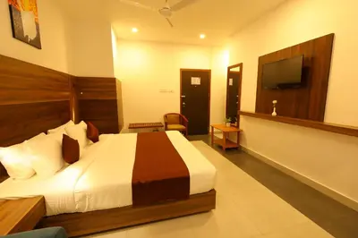 a hotel room with a bed and a flat screen tv at HOTEL LA SERENE Mattannur in Mattanūr