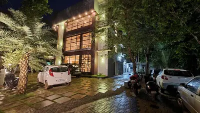 a building with cars parked in a parking lot at night at HOTEL LA SERENE Mattannur in Mattanūr