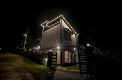 a house with lights on the side of it at night at Rendezvous in Coonoor