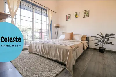 a bedroom with a bed and a large window at Rendezvous in Coonoor