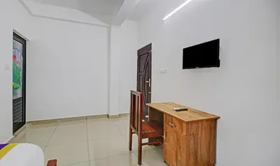a room with a desk and a television on a wall at Nirupama,Hotel Aluva 700 Mtr From Aluva Railway Station in Alwaye