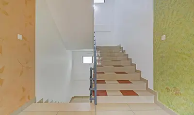 a staircase in a house with wooden floors at Nirupama,Hotel Aluva 700 Mtr From Aluva Railway Station in Alwaye
