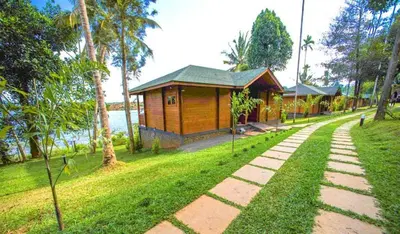 a small building in a park next to a path at LakeRose Wayanad Resort - Water Front Grandeur in Kalpetta