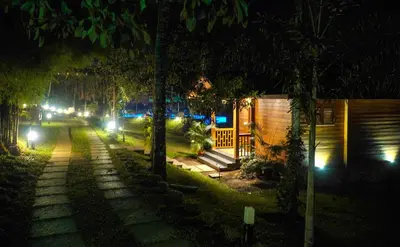 a night view of a street with a house and lights at LakeRose Wayanad Resort - Superior lake view in Kalpetta