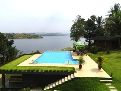a swimming pool with a view of a body of water at LakeRose Wayanad Resort - Superior lake view in Kalpetta