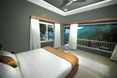 a bedroom with a bed and a balcony with windows at Casa Lucio Resorts in Mannārakkāt