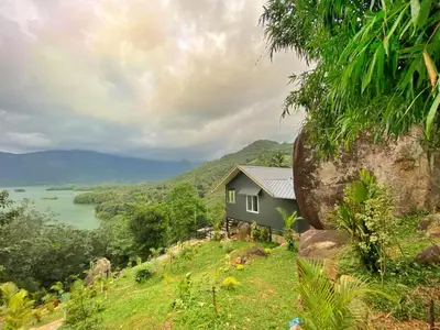 a small house on a hill with a large rock at Casa Lucio Resorts in Mannārakkāt