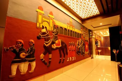 a wall with a painting of people on it at MC Suites Mysuru in Mysore