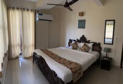 a bedroom with a bed and a ceiling fan at SAFARI QUEST in Mysore