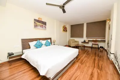 a bedroom with a large white bed and wooden floors at SAFARI QUEST in Mysore