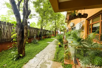 a sidewalk next to a house with a tree at SAFARI QUEST in Mysore