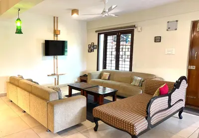 a living room with couches and a tv at SAFARI QUEST in Mysore