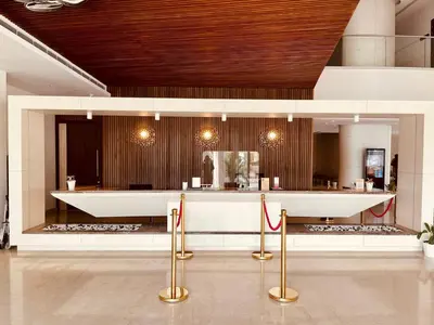 a bar in a room with a counter with gold posts at Dimora Kozhikode in Kozhikode