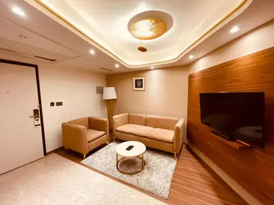 a living room with a couch and a flat screen tv at Dimora Kozhikode in Kozhikode