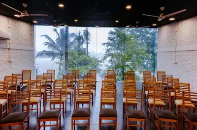 a row of chairs in a room with a large window at S RIVER RESORTS in Cochin