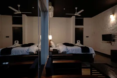 two beds in a room with two ceiling fans at S RIVER RESORTS in Cochin