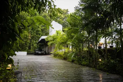 a cobblestone street with palm trees and a building at S RIVER RESORTS in Cochin