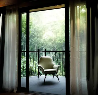 a chair sitting on a balcony next to a window at Vyna Hillock Resort in Vythiri