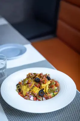 a white plate with a dish of food on a table at Zone Connect by The Park Coimbatore in Coimbatore