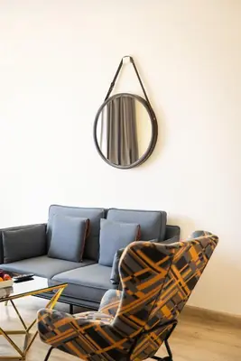 a mirror above a couch and a chair in a living room at Zone Connect by The Park Coimbatore in Coimbatore