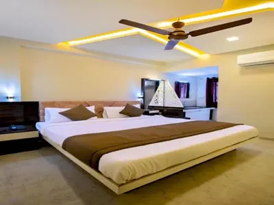 a bedroom with a large bed with a ceiling fan at IVY RESIDENCY in Coimbatore