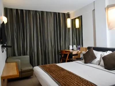 a hotel room with a bed and a desk at Nexstay Asma Tower in Kozhikode