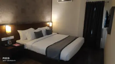 a bedroom with a large bed in a hotel room at Emperor-Hotel Rachana Continental Pvt Ltd in Kizhake Chālakudi