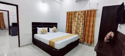 a bedroom with a bed with two cats on it at Suvarna Elite - Premium Apartment Hotel in Mysore