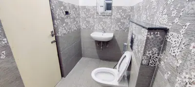 a bathroom with a toilet and a sink at Suvarna Elite - Premium Apartment Hotel in Mysore