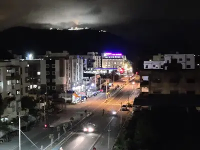 a city street at night with buildings and street lights at Suvarna Elite - Premium Apartment Hotel in Mysore