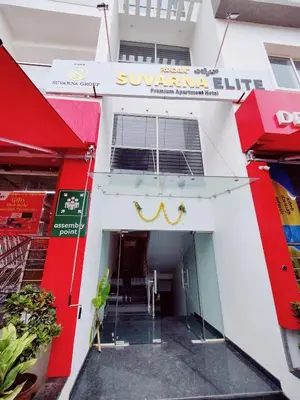 a store front of a white building with a revolving door at Suvarna Elite - Premium Apartment Hotel in Mysore