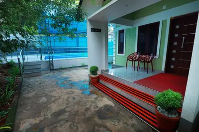 a porch of a house with two chairs and a table at NARMADA POOl VILLA in Angādipuram