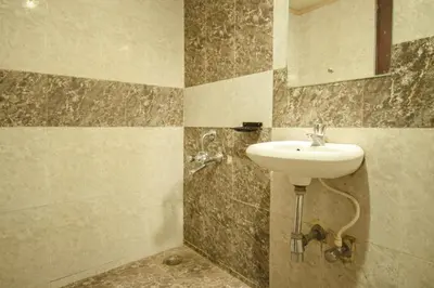 a bathroom with a sink and a mirror at Hotel Sunshine in Mysore