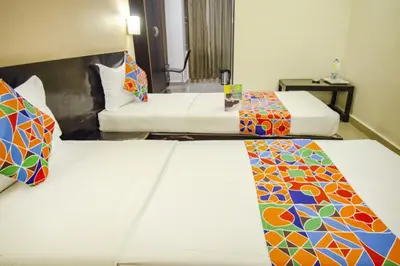 a hotel room with two beds with colorful patterns at Hotel Sunshine in Mysore