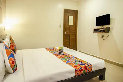 a room with a bed in a room with a television at Hotel Sunshine in Mysore