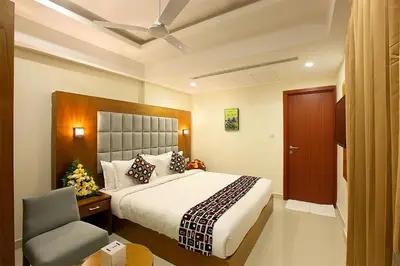 a hotel room with a bed and a chair at Lumbini Supreme in Trichūr