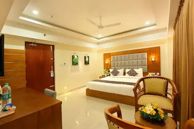 a hotel room with a bed and a desk and a room at Lumbini Supreme in Trichūr